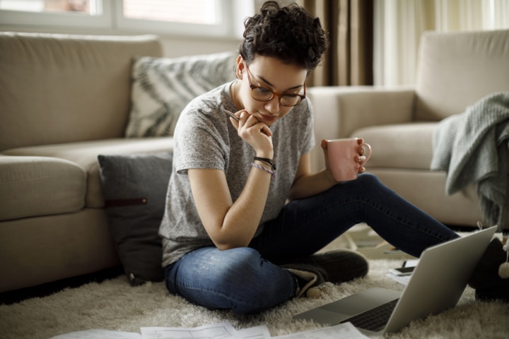 Mujer leyendo en su portátil sobre las Becas MEC para el curso académico 2025-2026