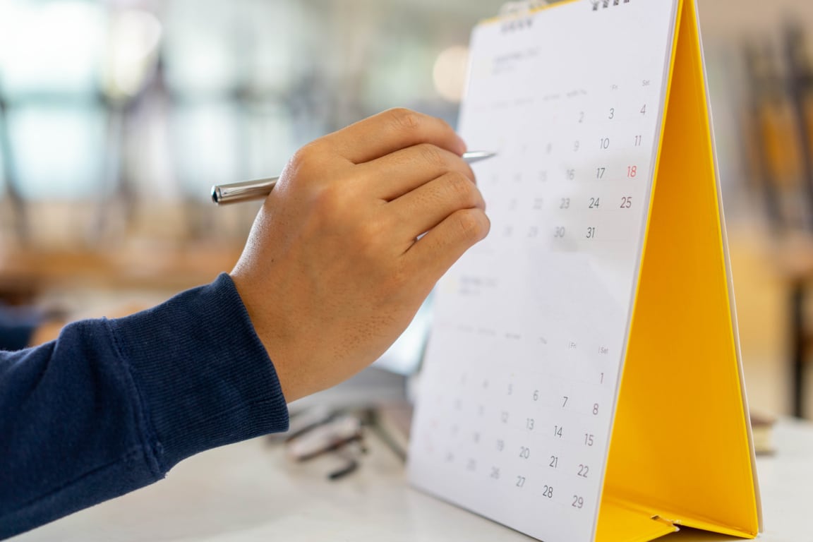Mano revisando el calendario laboral 2025 de España