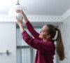 Persona poniendo luces lud en casa para ahorar en la factura de la luz