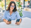 Mujer joven revisando su móvil, descubriendo cuáles son las nuevas limitaciones Bizum