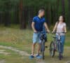 Una pareja celebra su traspaso del plan de pensiones montando en bicicleta en el campo.