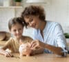 Madre e hija metiendo dinero en una hucha aprendiendo de ahorro