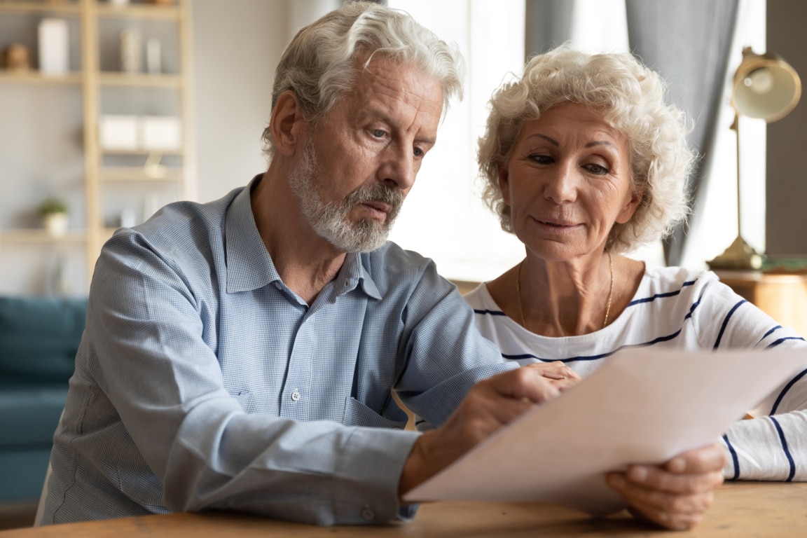 Dos personas comprobando ingresos y gastos en un papel para conocer su salud financiera personal