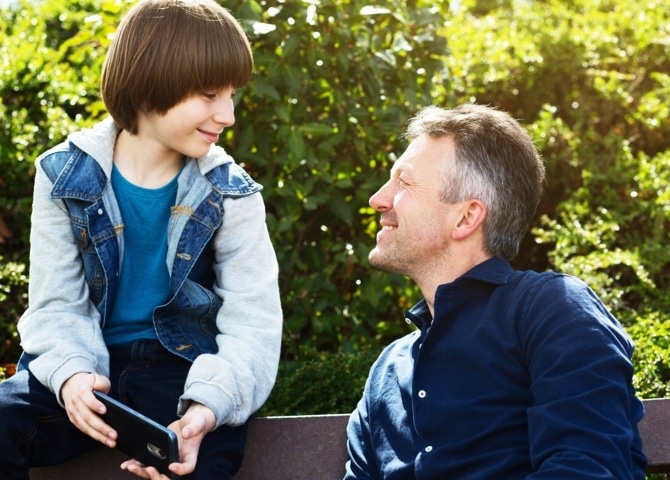 Padre con su hijo que tiene su primer móvil