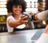Mujer pagando en un establecimiento a través de pagos digitales como el smartwatch.