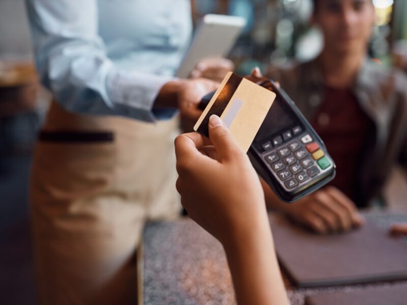 Mujer pagando con su tarjeta en un datáfono