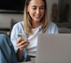 Mujer con su móvil y ordenador descubriendo cómo abrir una cuenta online