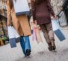 Mujeres caminando de espalda por la calle con bolsas de black friday en la mano