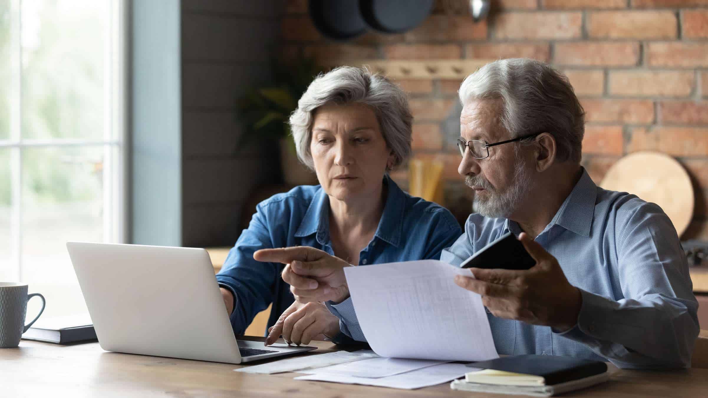 Pareja de señores mayores mirando cómo rescatar un plan de pensiones