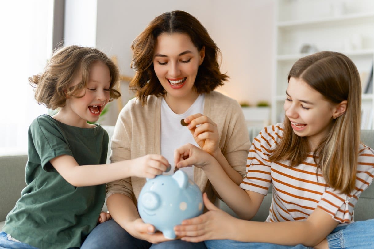 Mamá e hijos alegres y ahorrando, descubriendo que es una cuenta de ahorro