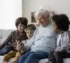 Abuelo y tres niños con un móvil descubriendo la brecha digital.