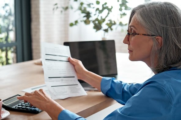 Mujer mayor mirando documentos y descubriendo cómo invertir para la jubilación