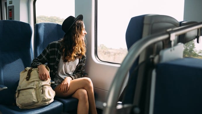 Mujer viaja sola en un tren, después de lograr ahorrar para un viaje