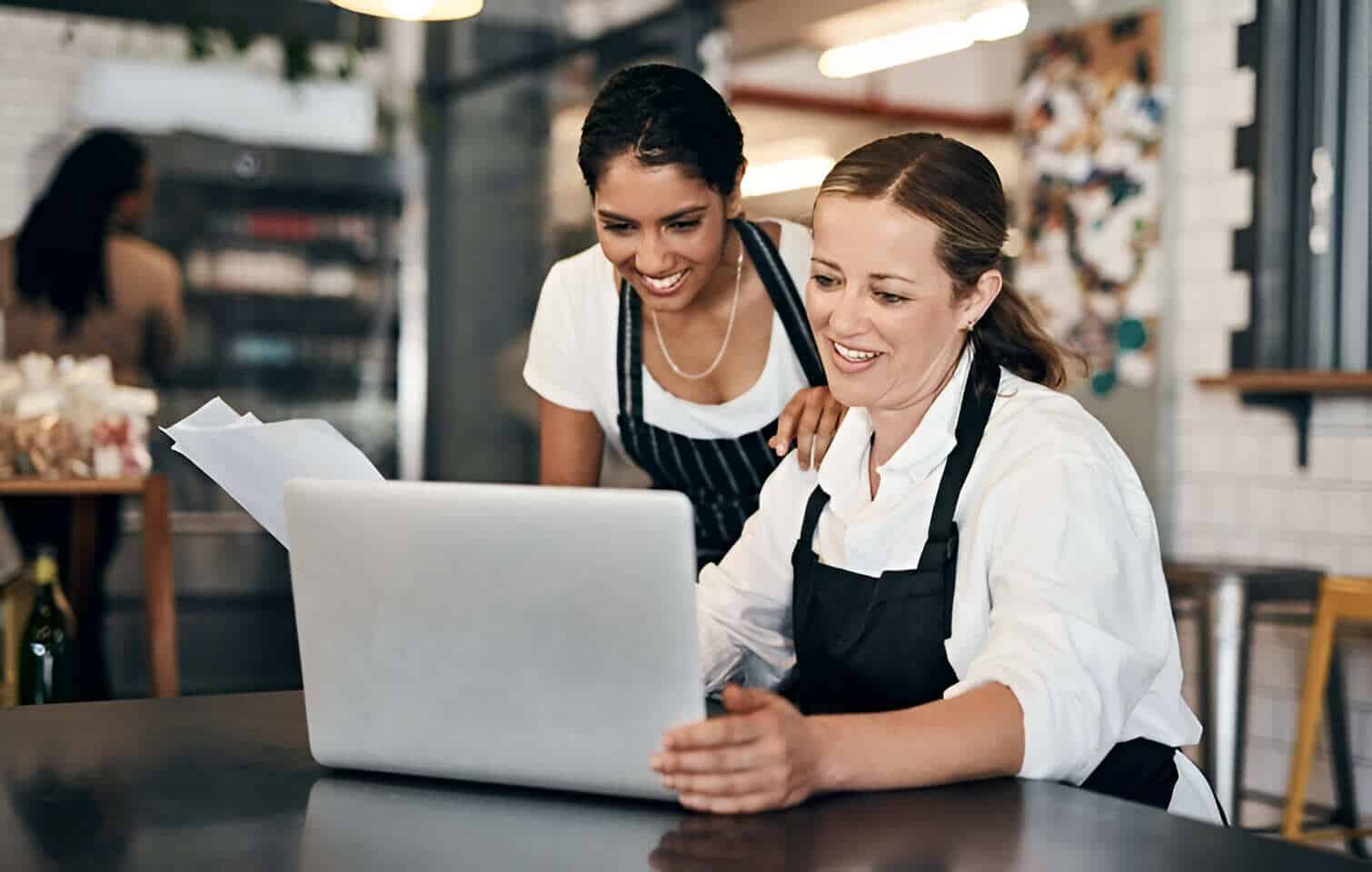Mujeres empresarias mirando las reseñas de clientes de su negocio