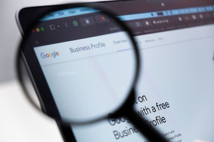 Una lupa enfocando un portatil con Google My Business Profile