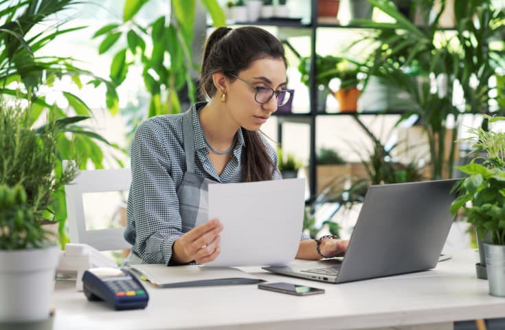Mujer joven revisando en el portátil cuánto es el irpf de los autonomos en 2024