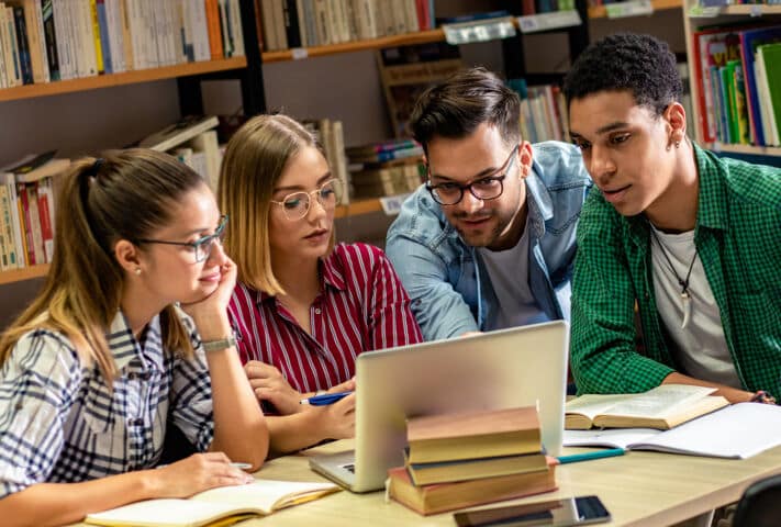 Grupo de amigos universitarios estudiantes, buscando cuánto cuesta una carrera universitaria en España en 2024-2025