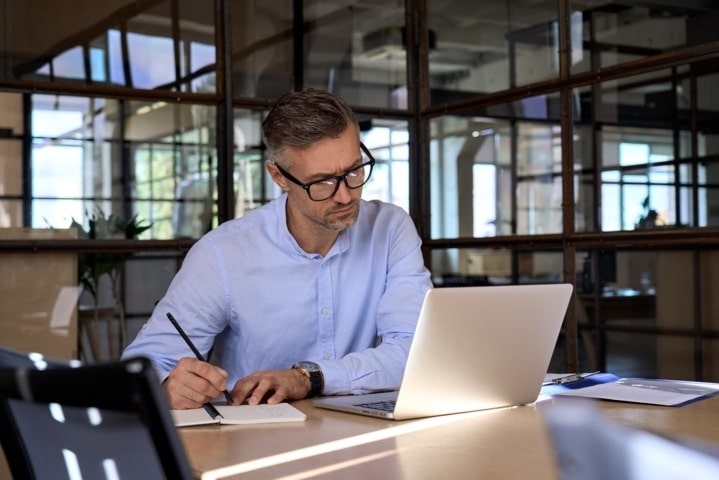 Hombre adulto revisando en su oficina el plan de continuidad del negocio que necesita