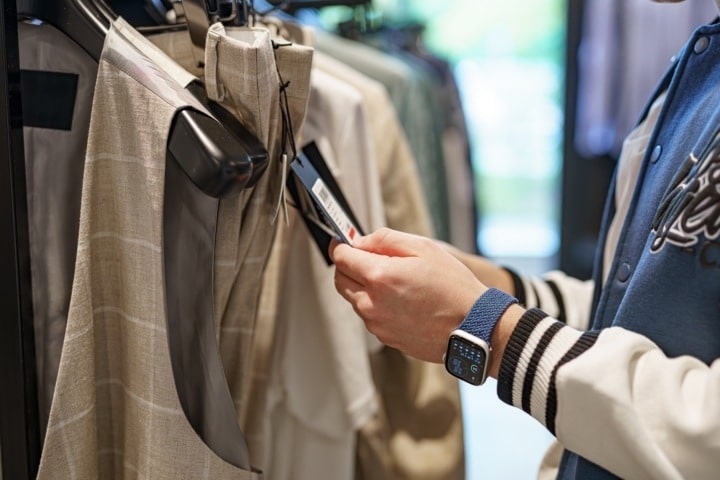 Persona mirando una etiqueta de ofertas, para calcular el descuento de un precio