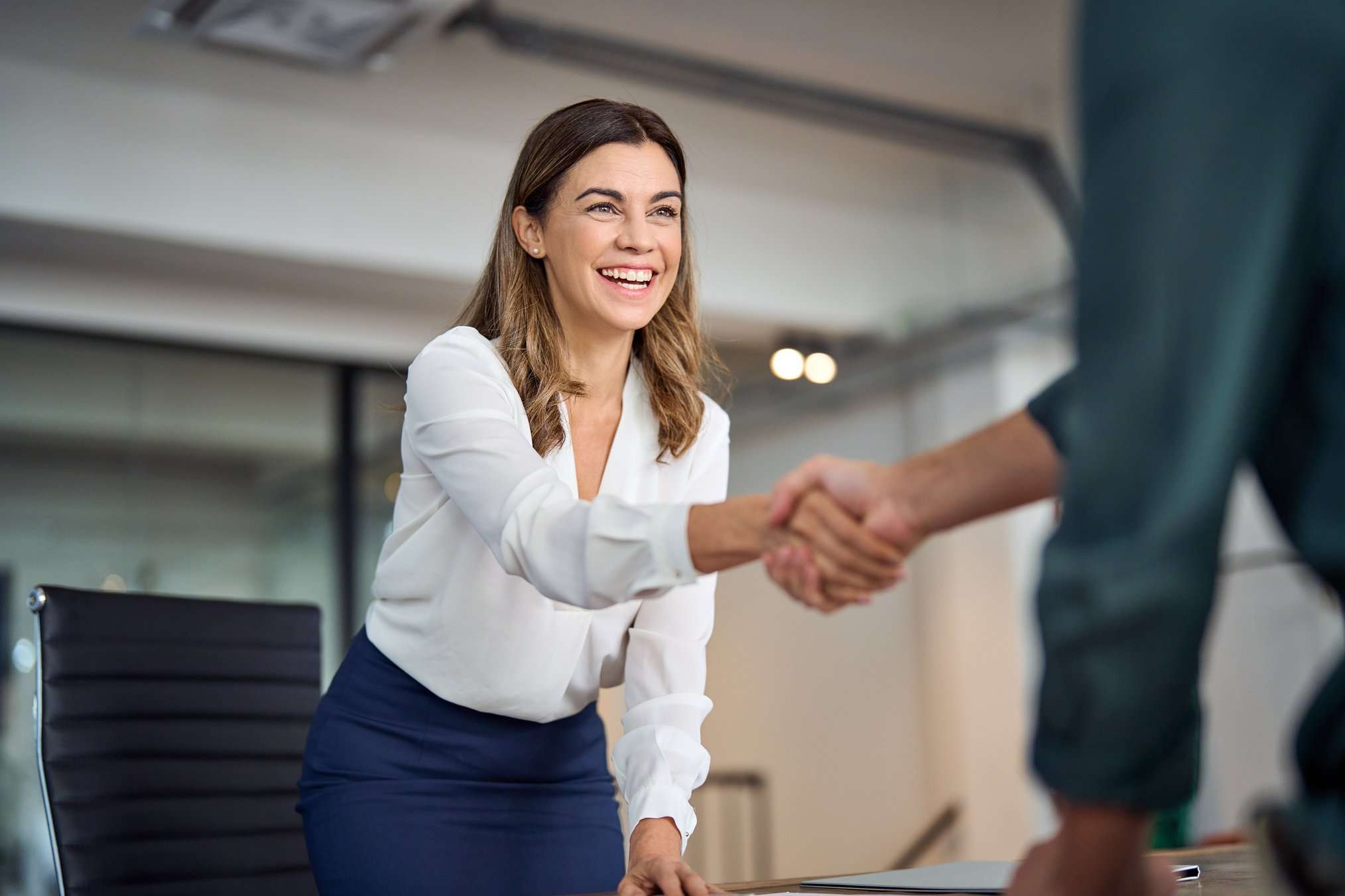 Mujer empresaria estrechando la mano, aplicando las técnicas de negociación en su comercio