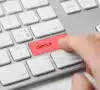 Mano en un botón de teclado de clickbait rojo