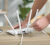 Manos conectando el router para proteger la red wifi de un hogar