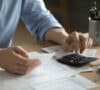 Hombre con calculadora haciendo presupuesto con ingresos variables