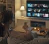 Mujer buscando películas sobre economía en la televisión de su sala de estar