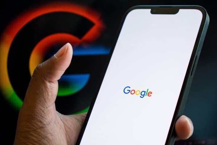 Mano sujetando un móvil con Google en pantalla